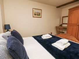 A bedroom with a bed, lamp, chair, desk, and wardrobe at Owl in Pickering