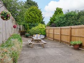 A garden with a table and benches at Owl in Pickering