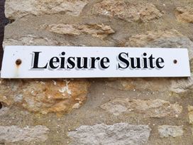 A sign reading Leisure Suite on a stone wall at Owl in Pickering