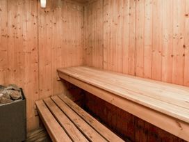 A sauna with wooden benches and a stone stove at Owl in Pickering