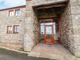 An entryway with a wooden door and stone wall at Shepherd's Barn Lancaster