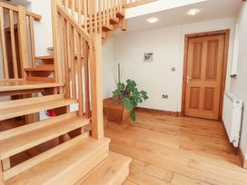 A hallway with a staircase and a plant at Shepherd's Barn Lancaster
