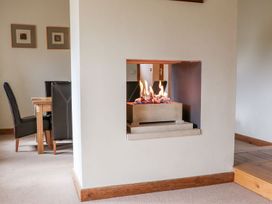 A dining room with a fireplace and dining table at Shepherd's Barn in Lancaster