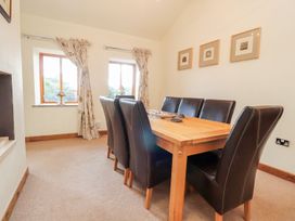 A dining room with a wooden table and chairs at Shepherd's Barn Lancaster