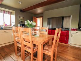 A kitchen with a wooden dining table and red stove at Shepherd's Barn in Lancaster