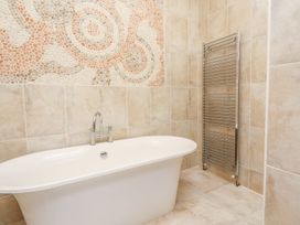 A bathroom with a bathtub and towel radiator at Shepherd's Barn in Lancaster