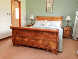 A bedroom with a wooden bed and bedside lamps at Shepherd's Barn in Lancaster