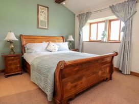 A bedroom with a wooden bed and bedside tables at Shepherd's Barn in Lancaster
