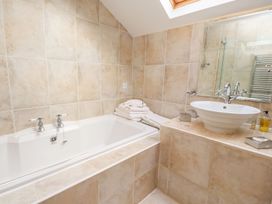 A bathroom with a bathtub and wash basin at Shepherd's Barn Lancaster