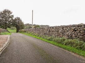A road bordered by stone walls and trees at Shepherd's Barn in Lancaster