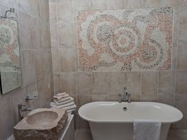 A bathroom with a bathtub, sink, and towels at Shepherd's Barn in Lancaster