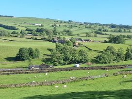 A view of sheep grazing in fields near farm buildings at Shepherd's Barn in Lancaster