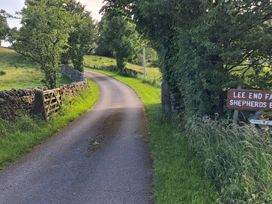 A gravel road with trees and a sign at Shepherd's Barn in Lancaster