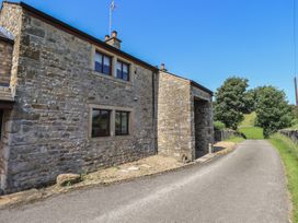 A stone building with windows beside a road at Shepherd's Barn in Lancaster