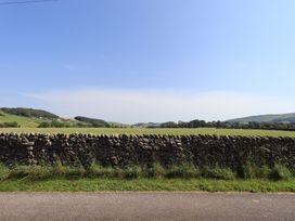 A stone wall with a field and road at Shepherd's Barn in Lancaster
