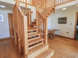 A staircase with a wooden railing in a hallway at Shepherd's Barn, Lancaster