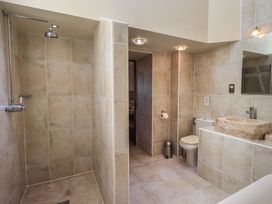 A bathroom with shower, toilet, and stone sink at Shepherd's Barn, Lancaster
