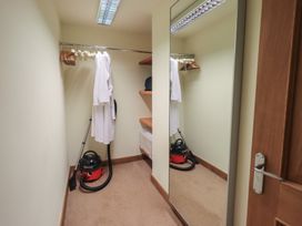 A closet with hanging robes and a vacuum cleaner at Shepherd's Barn in Lancaster
