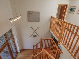 A hallway with a staircase and chandelier at Shepherd's Barn in Lancaster