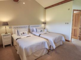 A bedroom with two single beds and a bedside lamp at Shepherd's Barn in Lancaster