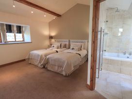 A bedroom with two beds and a bathroom area at Shepherd's Barn in Lancaster