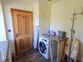 A laundry room with a washing machine and ironing board at Shepherd's Barn in Lancaster