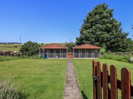 An outdoor area with two outbuildings and a path at Shepherd's Barn in Lancaster