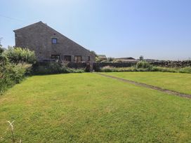A garden with a house and stone wall at Shepherd's Barn Lancaster