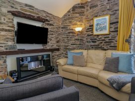 A living room with a television and a sofa at Hillside Cottage in Bowness-On-Windermere
