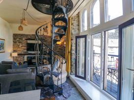 A living room with a spiral staircase and sofa at Hillside Cottage in Bowness-On-Windermere