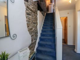A hallway with a staircase and mirror at Hillside Cottage in Bowness-On-Windermere