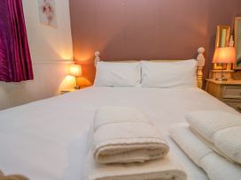 A bedroom with a bed and towels on display at Hillside Cottage Bowness-On-Windermere