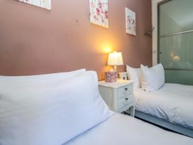 A bedroom with two beds and a nightstand at Hillside Cottage in Bowness-On-Windermere