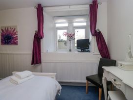 A bedroom with a bed and window at Hillside Cottage in Bowness-On-Windermere