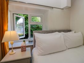 A bedroom with a bed and lamp at Hillside Cottage in Bowness-On-Windermere