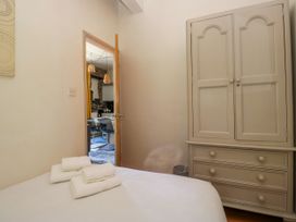 A bedroom with a wardrobe and towels on the bed at Hillside Cottage Bowness-On-Windermere