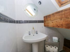 A bathroom with a sink, mirror, and towel holder at Hillside Cottage in Bowness-On-Windermere