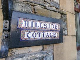 A sign displaying 'Hillside Cottage' on a stone wall at Hillside Cottage in Bowness-On-Windermere