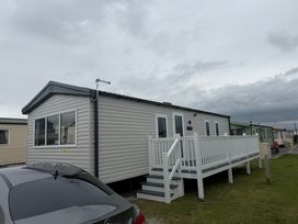 A mobile home with a white railing and steps at Trecco bay holiday park- Magnolia 11 Porthcawl