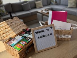 A basket with items and a welcome sign in a living room at Trecco bay holiday park- Magnolia 11 Porthcawl
