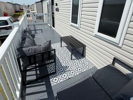 A patio area with a sofa and table at Trecco bay holiday park- Magnolia 11, Porthcawl