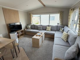 A living room with a sofa and television at Trecco bay holiday park- Magnolia 11 Porthcawl