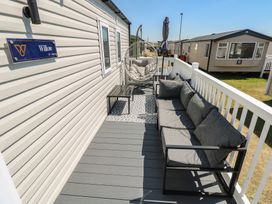 An outdoor space with a sofa and hanging chair at Trecco Bay Holiday Park - Magnolia 11 in Porthcawl