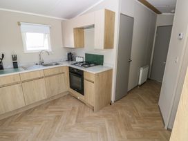 A kitchen with a sink and stove at Trecco Bay Holiday Park - Magnolia 11 Porthcawl