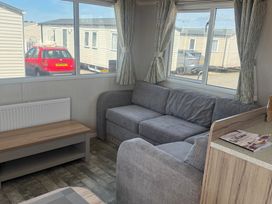 A living room with a sofa and coffee table at Trecco Bay in Porthcawl