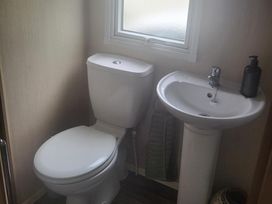 A bathroom with a toilet and sink at 164 Broadland Sands Holiday Park in Lowestoft