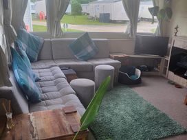 A living room with a sofa and television at 164 Broadland Sands Holiday Park in Lowestoft
