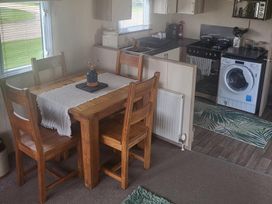 A kitchen with a table and chairs at 164 Broadland Sands Holiday Park in Lowestoft