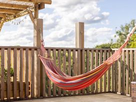 An outdoor space with a hammock and wooden railing at the property