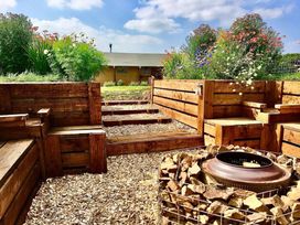A garden with wooden seating and a fire pit at The Old Barn in Manchester